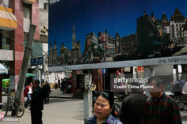 People walk past a property billboard on April 16, 2007 in Wuhan of Hubei Province, China. According to data with the National Development and Reform...