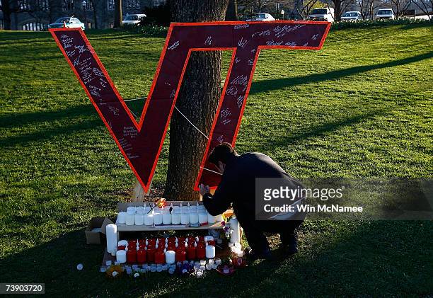Virginia Tech student Daniel Hamilton writes on a memorial constructed on the Virginia Tech campus for the victims of yesterday's mass killings April...