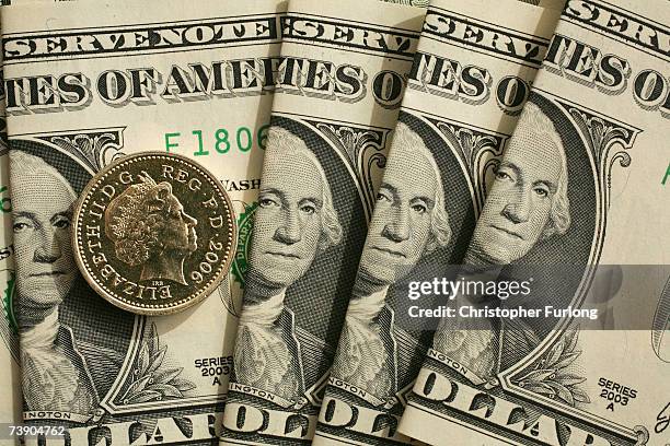 In this photo illustration a British pound coin can be seen next to American Dollar notes on April 17, 2007 in Manchester, England. The British pound...