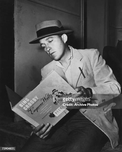 American actor and singer Bing Crosby examines the soundtrack to 'The Emperor Waltz', his latest musical, 1948.