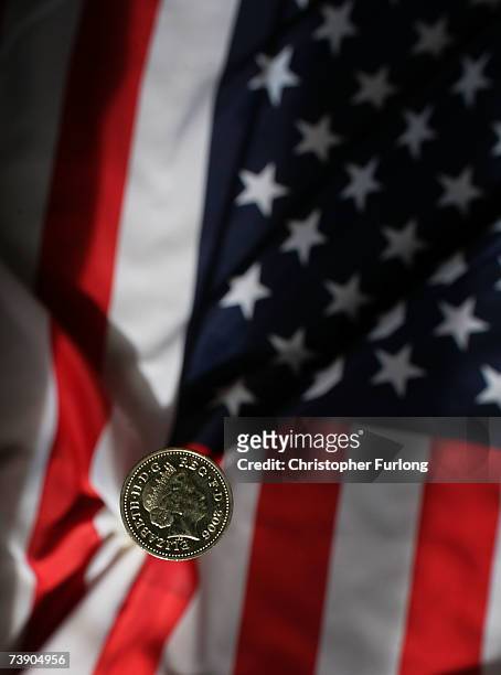 In this photo illustration a British pound coin can be seen next to the American Flag on April 17, 2007 in Manchester, England. The British Pound has...