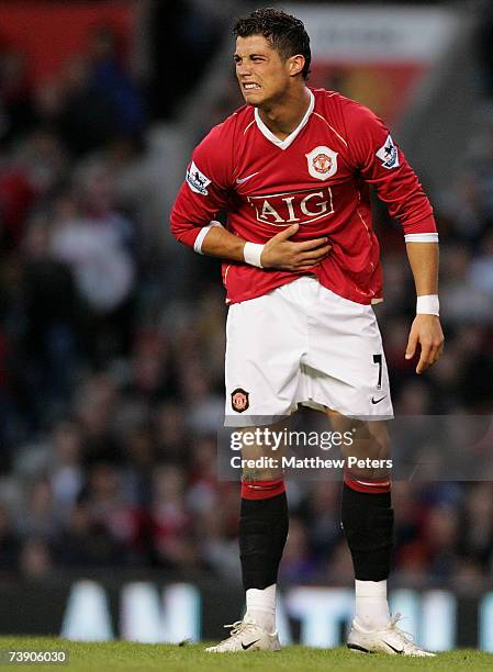 Cristiano Ronaldo of Manchester United shows his pain at a stomach injury during the Barclays Premiership match between Manchester United and...