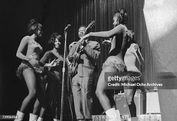 Blues musician B.B. King performs onstage with his Gibson hollowbody electric guitar nicknamed "Lucille" and back up dancers in 1963 at the Apollo...