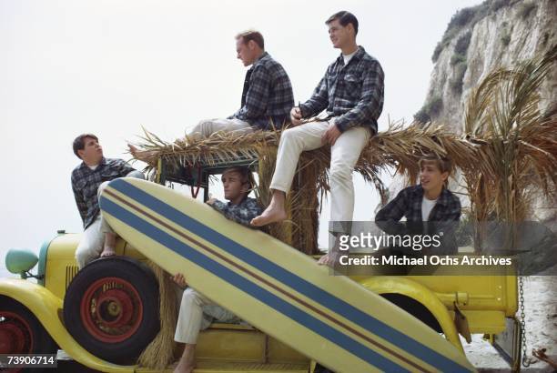 Rock and roll band The Beach Boys pose for a portrait with a vintage "Woody" station wagon in August 1962 in Los Angeles, California. Carl Wilson,...