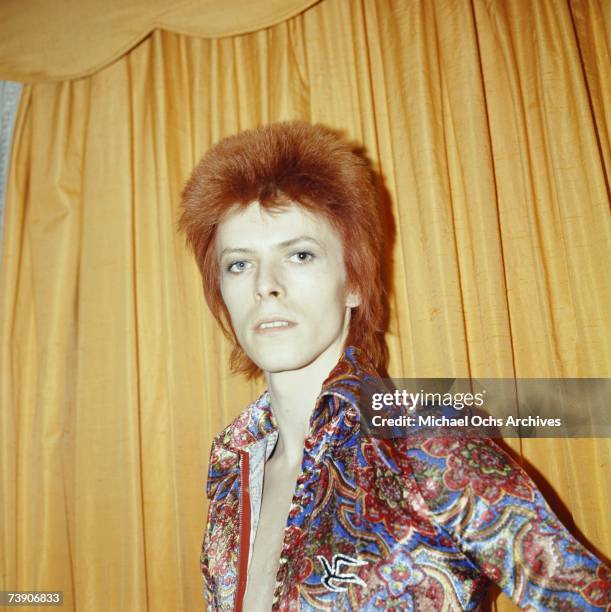 Rock and roll musician David Bowie poses for a portrait dressed as 'Ziggy Stardust' in a hotel room in 1973 in New York City, New York.