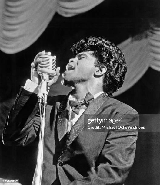 Soul singer James Brown sings in to a vintage microphone as he performs onstage in 1962 in New York, New York.