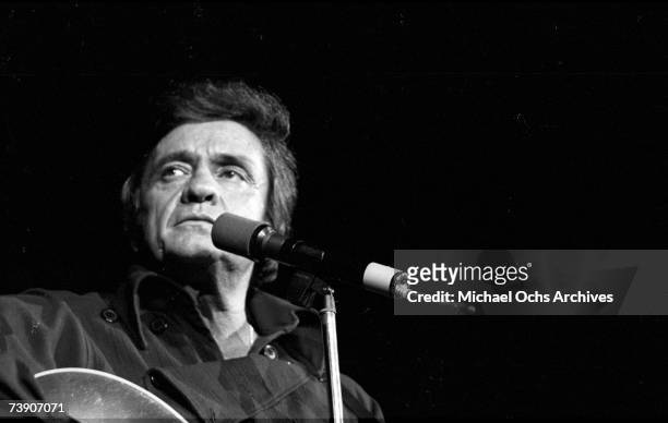 Country singer/songwriter Johnny Cash plays acoustic guitar as he performs onstage at the Anaheim Convention Center on March 11, 1978 in Anaheim,...