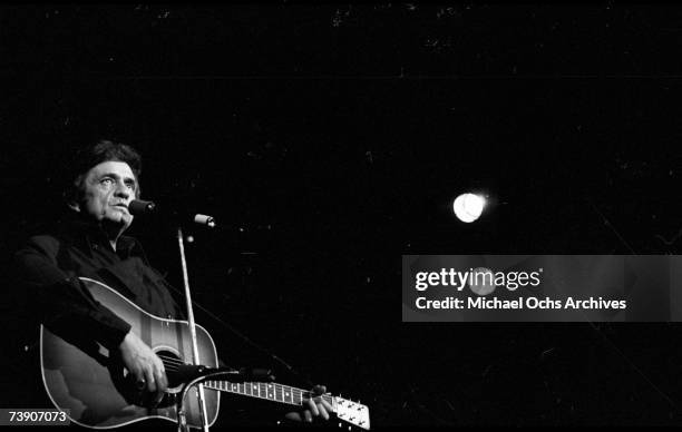 Country singer/songwriter Johnny Cash plays acoustic guitar as he performs onstage at the Anaheim Convention Center on March 11, 1978 in Anaheim,...