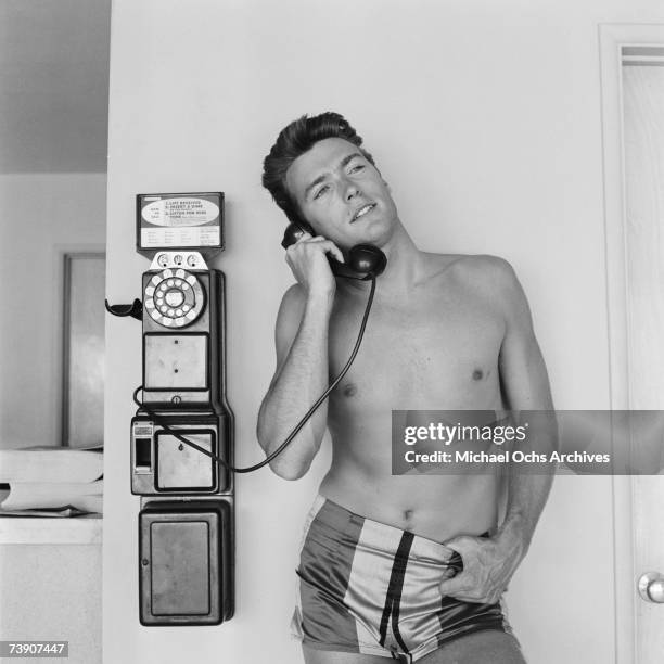 Actor Clint Eastwood talks on a pay phone outside his home on June 1, 1956 in Los Angeles, California.