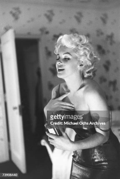 Actress Marilyn Monroe poses for a candid portrait with a bottle of Chanel No. 5 perfume on March 24, 1955 at the Ambassador Hotel in New York City,...