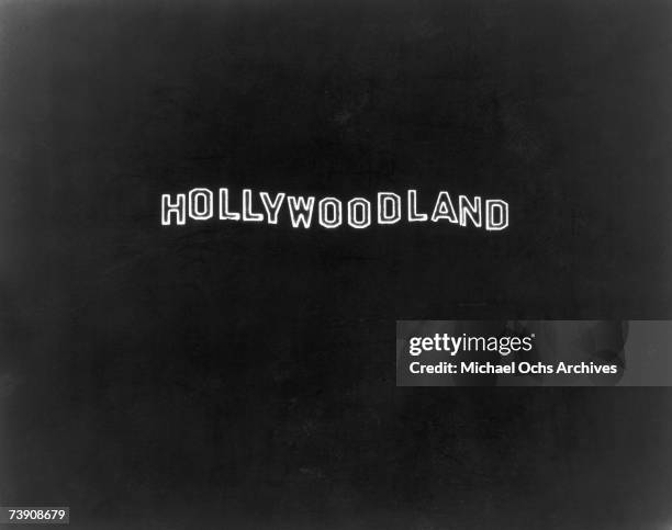 The illuminated Hollywoodland sign at night on Mount Lee in the Hollywood Hills, overlooking Hollywood in Los Angeles, California. The 'land' part of...