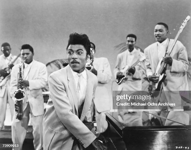 Musician Little Richard performs onstage with his band as his saxophone player Grady Gaines stands on the piano in circa 1957 in scene from the movie...