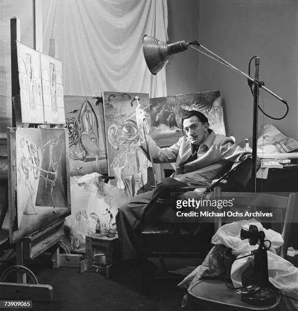 Surrealist artist Salvador Dali poses with his oil paintings at his studio on the 8th floor of the Zeigfeld Theatre in 1943 in New York City, New...