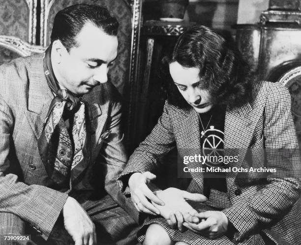 Belgian Jazz guitarist Django Reinhardt has his palm read by French singer Edith Piaf circa 1947 in Paris, France.