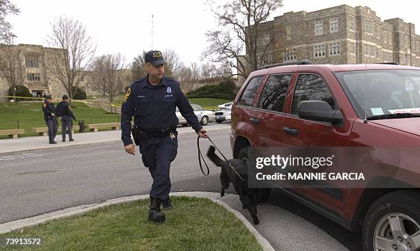 Blacksburg, UNITED STATES: A Virginia State Trooper with a bomb-sniffing dog responds to a perceived threat 18 April , 2007 at Virginia Tech's...