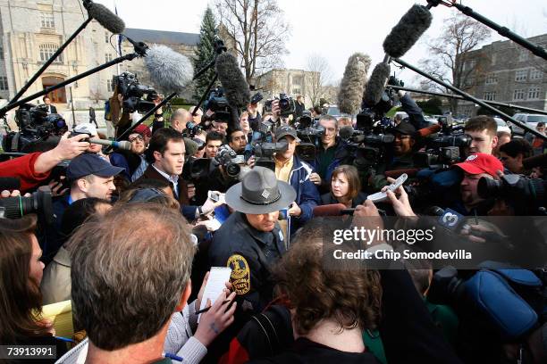 Virginia State Police public information officer Sgt. F.L. Tyler , takes questions from the news media outside Burruss Hall and Norris Hall after...