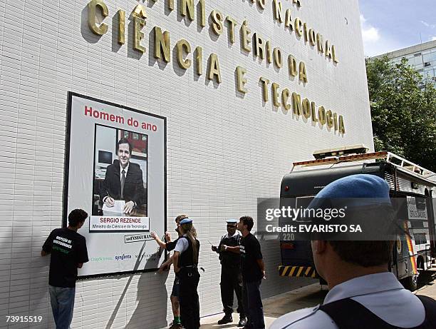 Members of the Police talk with Greenpeace activists as they stick a poster on the facade of the Ministry of Science and Technology in Brasilia, to...