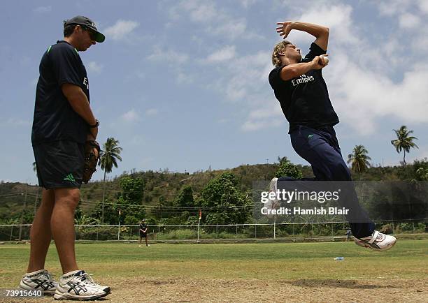 Shane Watson of Australia bowls with bowling coach Troy Cooley looking on during training at La Sagesse Cricket Ground on April 18 in St George's,...