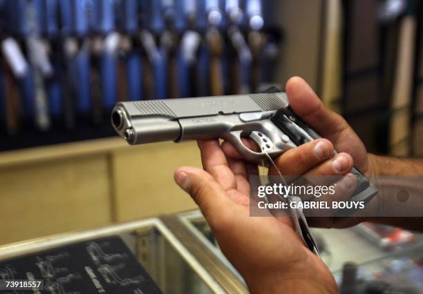 Glendale, UNITED STATES: A man chooses a gun at the Gun Gallery in Glendale, California, 18 April 2007. The massacre at Virginia Tech has ignited...