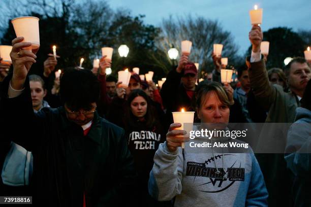 People hold candles during a candlelight vigil to memory the victims of the Virginia Tech shooting rampage April 18, 2007 in Old Town Alexandria,...