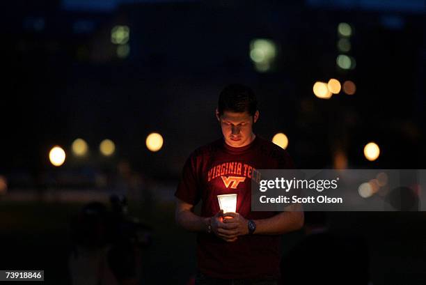 Virginia Tech sophmore Kenneth Erisman from Switzerland holds a candle near a memorial for the people killed in Monday's shooting spree April 18,...