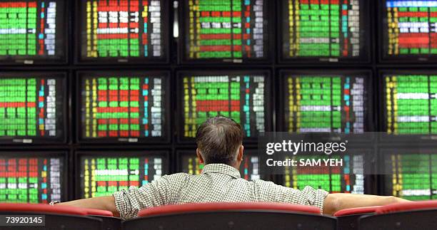 Local investor sits in front of monitors showing the stocks index at a securities house in Taipei 19 Arpil 2007. Taiwan share prices closed 1.43...