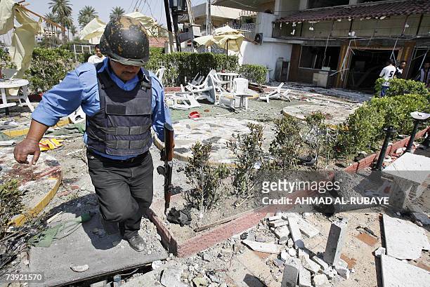An Iraqi policeman walks amid rubble at the site where a suicide car bomber killed at 12 people in Baghdad, 19 April 2007. The bomber blew up his car...
