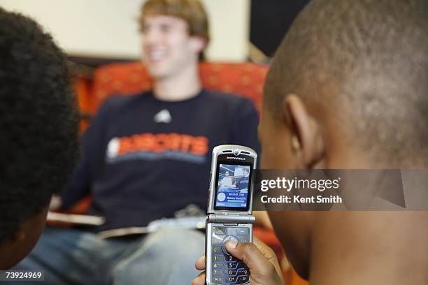 Fan uses a cell phone to take a picture of Matt Carroll of the Charlotte Bobcats during a Read to Achieve Event on March 13, 2007 in Charlotte, North...