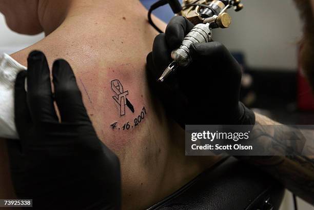 Virginia Tech junior Adam Kiser gets a tattoo memorializing the victims of Monday's shooting on the school's campus from tattoo artist James Babb...