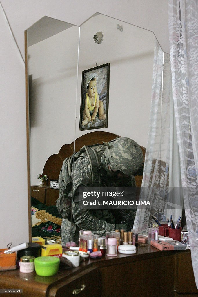 A US soldier searches an Iraqi family ro...