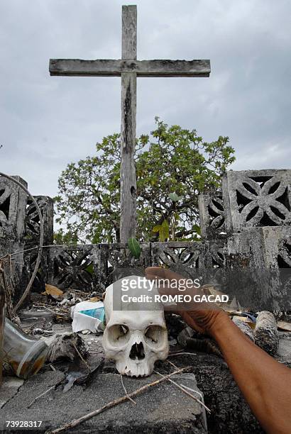 Siquijor, PHILIPPINES: TO GO WITH STORY: PHILIPPINES-MAGIC-WITCHCRAFT-SORCERER by Karl Wilson A villager touches a human skull use used for their...