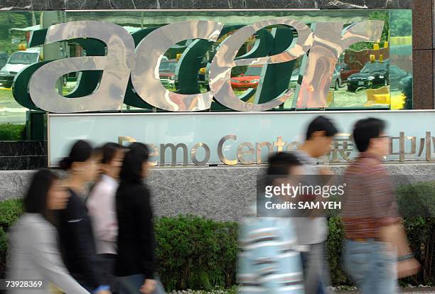 People walk past a logo of Acer in Shichih, Taipei county, 20 April 2007. Preliminary figures from a research house showed 20 April 2007 personal...