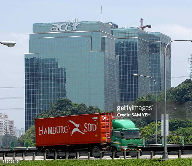 Truck drives by the logo of Acer displayed on a high rise building in Shichih, Taipei county, 20 April 2007. Preliminary figures from a research...