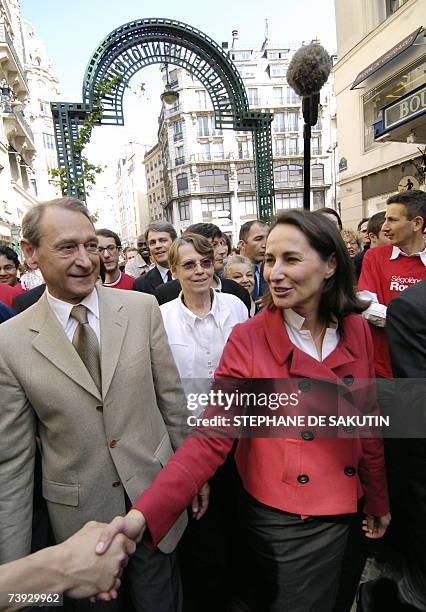 French Socialist Party presidential candidate Segolene Royal , flanked by Paris' mayor Bertrand Delanoe shakes hands with an inhabitant upon her...