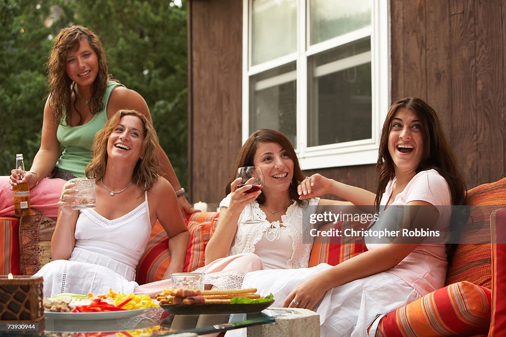 Woman dressed in white sitting on sofa outside