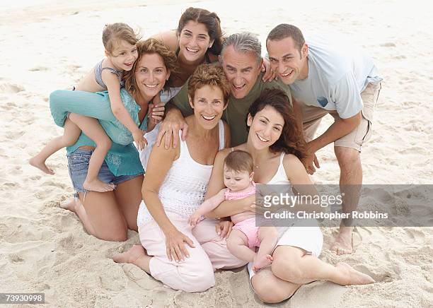 three generations of family with children (12 months to 7 years) on sandy beach - 50 years old man imagens e fotografias de stock