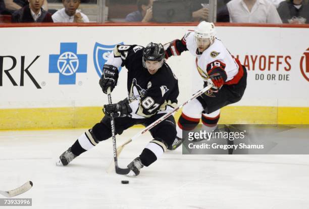Sidney Crosby of the Pittsburgh Penguins plays the puck as Jason Spezza of the Ottawa Senators pressures him in game 4 of the Eastern Conference...