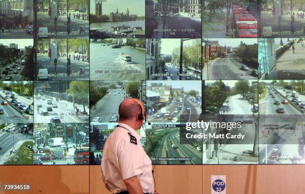 Police officer watches banks of television monitors showing a fraction of London's CCTV camera network in the Metropolitan Police's new Special...