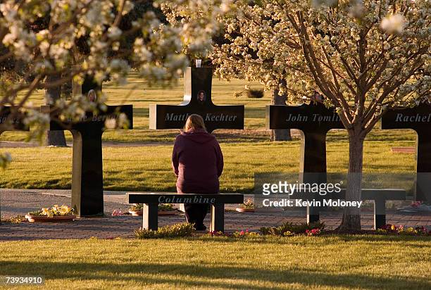 An unidentified mourner pauses at a memorial that stands around the graves of three of the Columbine High School shooting victims at Chapel Hill...