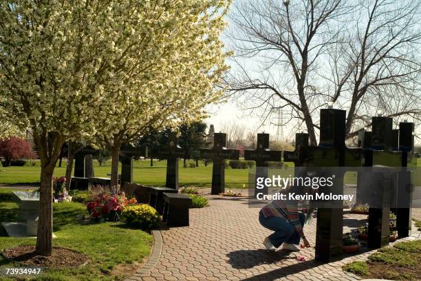 Marilyn Bell, of Littleton, CO, leaves a flower each for the victims of the Columbine High School shootings in 1999, at a memorial at Chapel Hill...