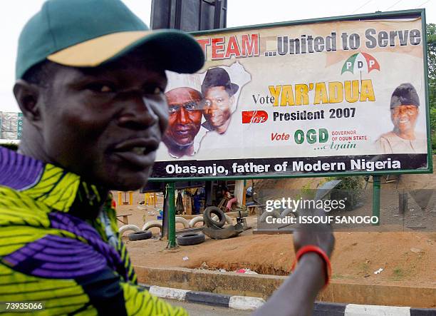 Supporter of People's Democratic Party , the party of outgoing president Olusegun Obasanjo, points to a party poster 20 April 2007 in Abeocuta ahead...