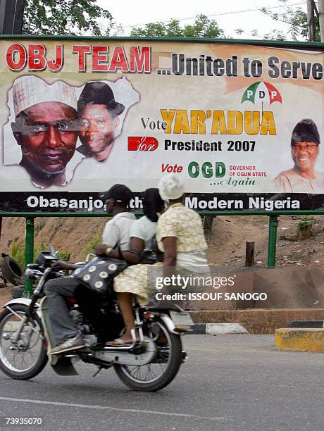 Taxi-moto drives past a People's Democratic Party , party poster 20 April 2007 in Abeocuta ahead of elections 22 April. There are 25 candidates for...