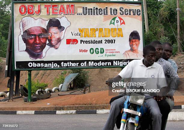 Taxi-moto drives past a People's Democratic Party , party poster 20 April 2007 in Abeocuta ahead of elections 22 April. There are 25 candidates for...