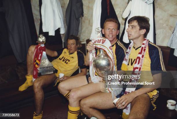 Arsenal footballers, from left, Paul Merson, Perry Groves and Alan Smith celebrate in their dressing room with the League trophy and the Barclays...