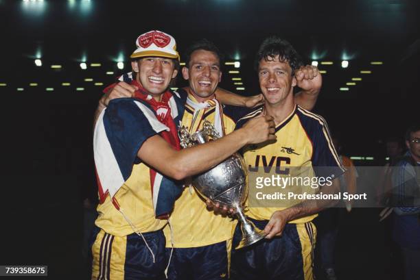 Arsenal footballers, from left, Tony Adams, Steve Bould and David O'Leary celebrate with the League trophy after beating Liverpool FC 2-0 away at...