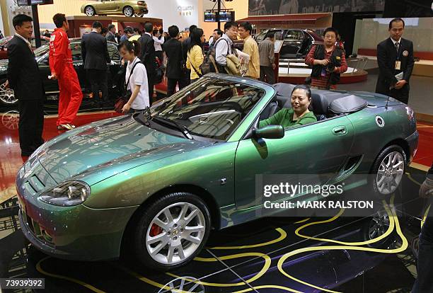 Chinese woman tries out an MG 7 convertible in the Nanjing Auto companies display at the Auto Shanghai exhibition, 21 April 2007. Nanjing Auto's MG...