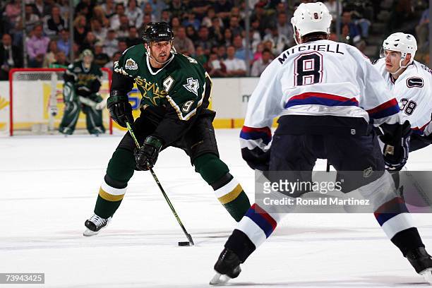 Mike Modano of the Dallas celebrates moves the puck against Willie Mitchell of the Vancouver Canucks during game six of the 2007 NHL Western...