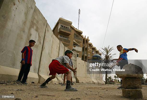 Iraqi boys play football near a blast wall on April 22, 2007 in the Karrada neighborhood of Baghdad, Iraq. U.S troops are building a wall, that the...