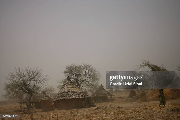 Chadian woman walks with her son near abandoned huts in the Aramgo village that was attacked by Janjawid southwest of Goz Beida April 22, 2007 in...
