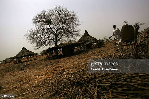Chadian man walks near burned and abandoned huts in the Aramgo village that was attacked by Janjawid south west of Goz Beida April 22, 2007 in Chad....
